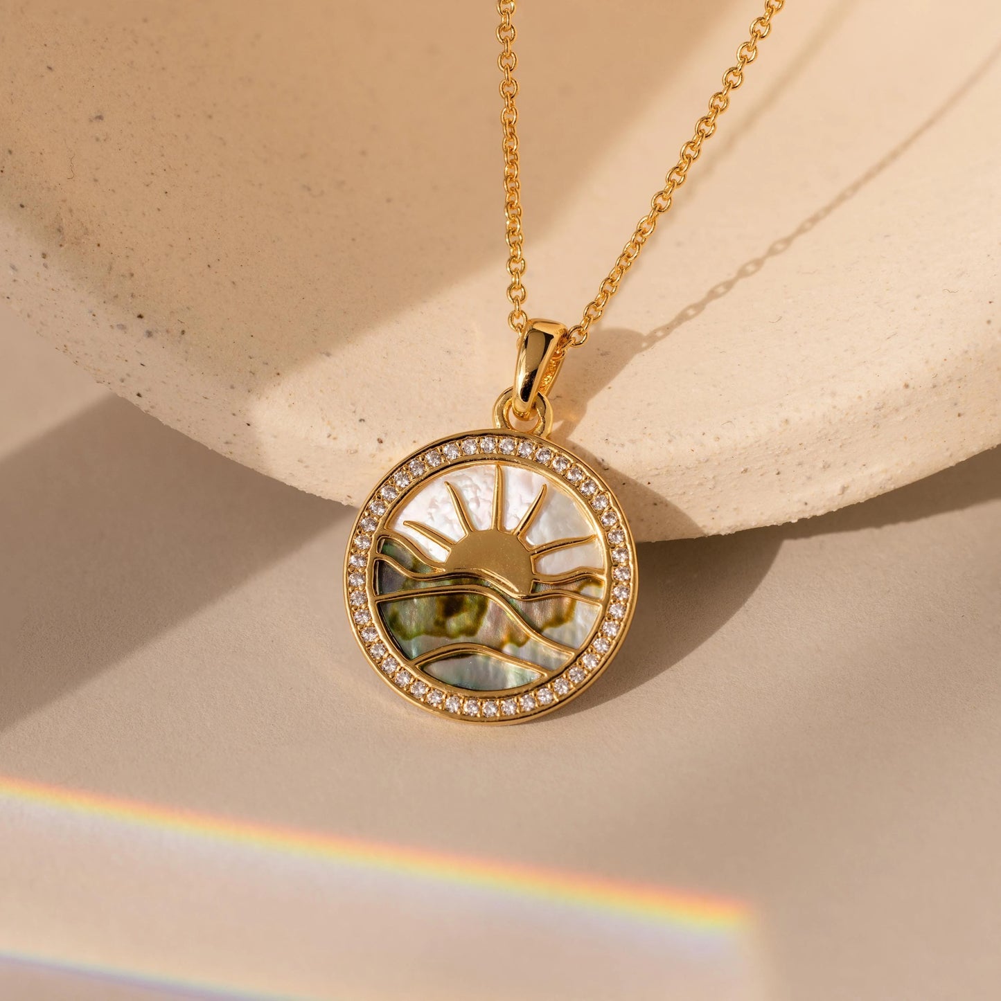 An 18-carat gold sunrise necklace, handcrafted from abalone and pearls